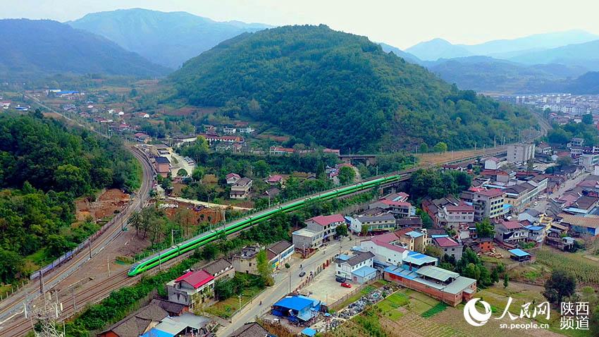 2021年9月30日，陽平關(guān)至安康跑起“復(fù)興號(hào)”動(dòng)車組，標(biāo)志秦巴深處的陽安鐵路全線邁入動(dòng)車新時(shí)代。圖為陽平關(guān)至安康“復(fù)興號(hào)”動(dòng)車在秦巴山區(qū)的崇山峻嶺間穿行。郝正國攝