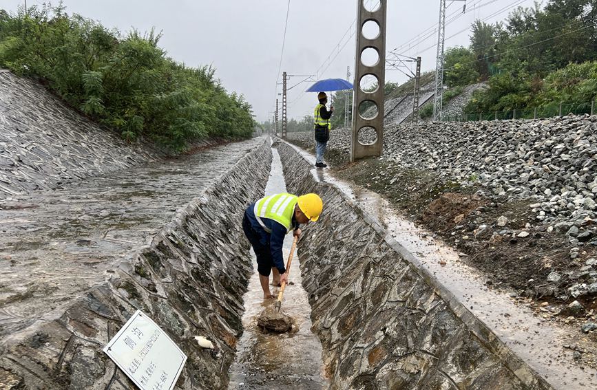 漢中工務(wù)段西鄉(xiāng)線路車間防洪人員在陽安線西鄉(xiāng)至沙河坎區(qū)間清理水溝。金嶸攝