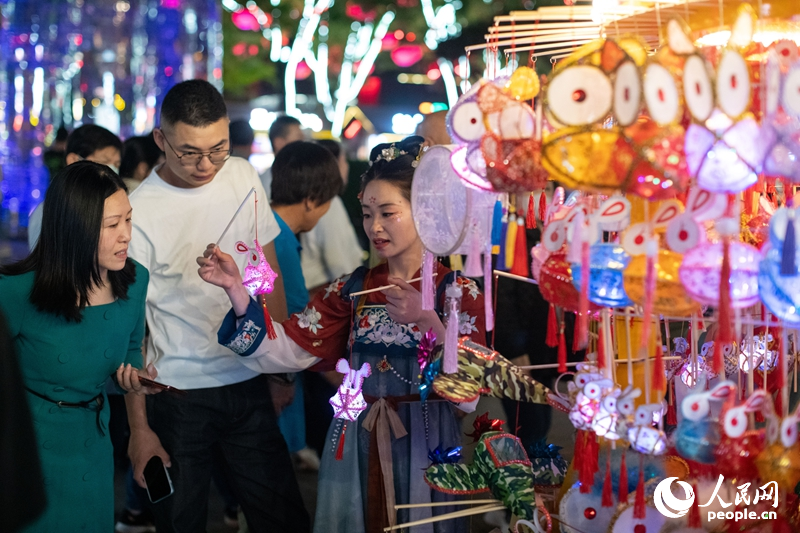 在西安大唐不夜城步行街，游客正在選購手工藝品。人民網(wǎng)記者 翁奇羽攝