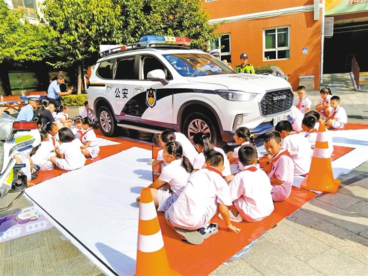 9月1日上午，西安公安交警雁塔大隊(duì)小寨中隊(duì)民警在翠華路小學(xué)開(kāi)展交通安全宣講。圖為學(xué)生觀察體驗(yàn)汽車駕駛盲區(qū)。